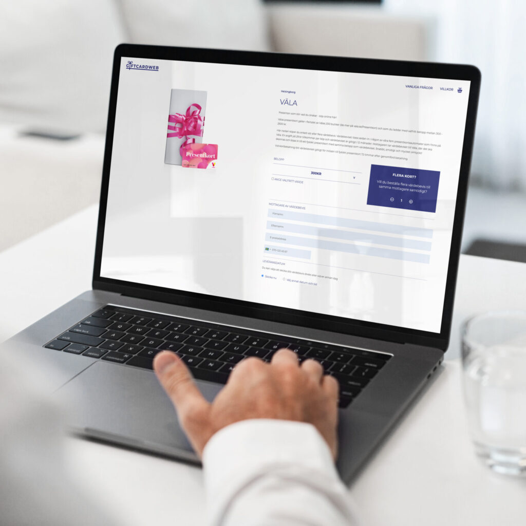 Person bruker en laptop for å kjøpe et gavekort på en nettbasert plattform, Giftcardweb.